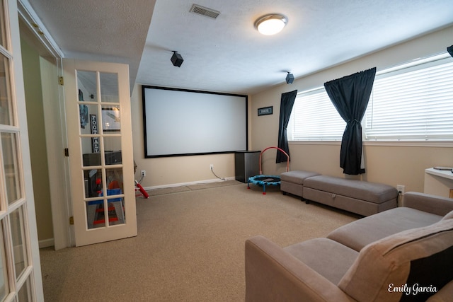 carpeted cinema room featuring french doors and a textured ceiling