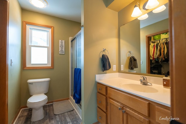 bathroom with vanity, toilet, hardwood / wood-style floors, and a shower with shower door