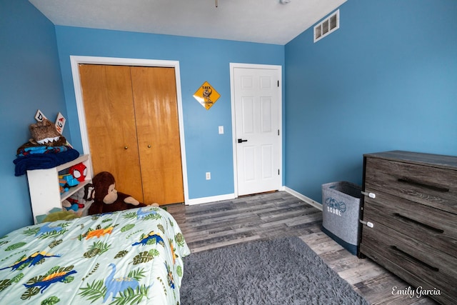 bedroom with dark hardwood / wood-style floors and a closet