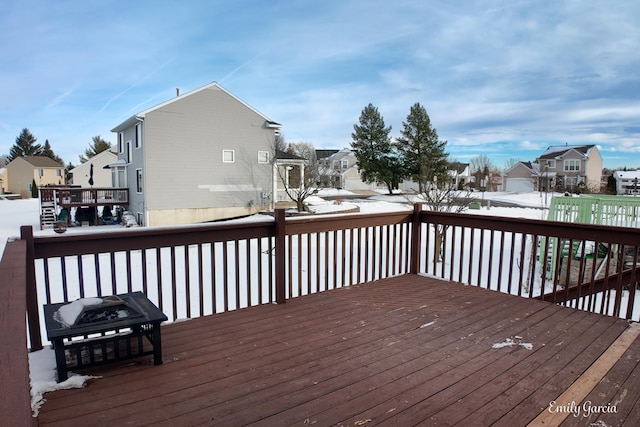 snow covered deck featuring a fire pit