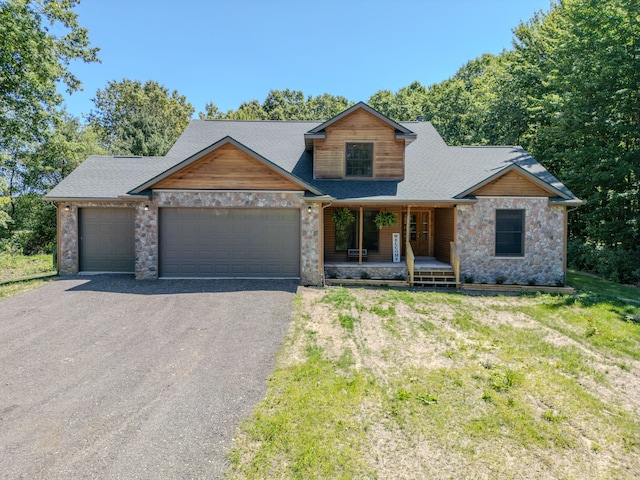 view of front of home with a garage, a front lawn, and a porch