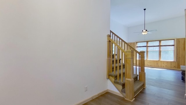 stairs with hardwood / wood-style flooring and ceiling fan