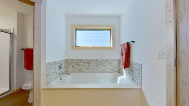 bathroom featuring a bathtub, toilet, and hardwood / wood-style flooring