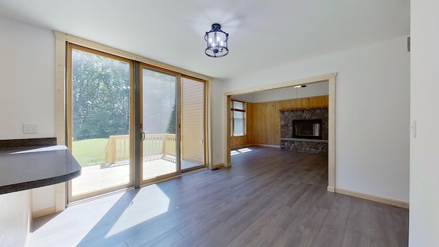 entryway with expansive windows, a fireplace, dark hardwood / wood-style floors, and wooden walls