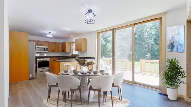 dining area with expansive windows and light hardwood / wood-style flooring