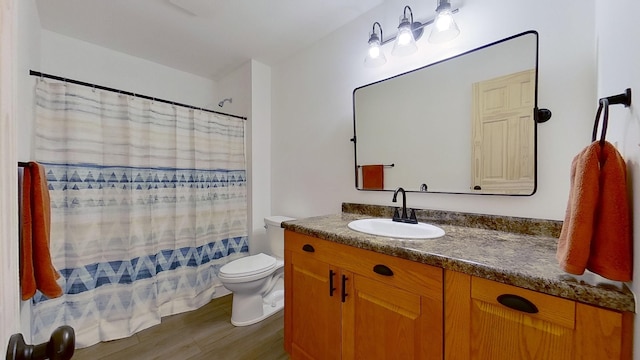 bathroom with vanity, hardwood / wood-style floors, curtained shower, and toilet