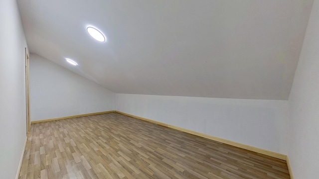 additional living space with lofted ceiling and light wood-type flooring