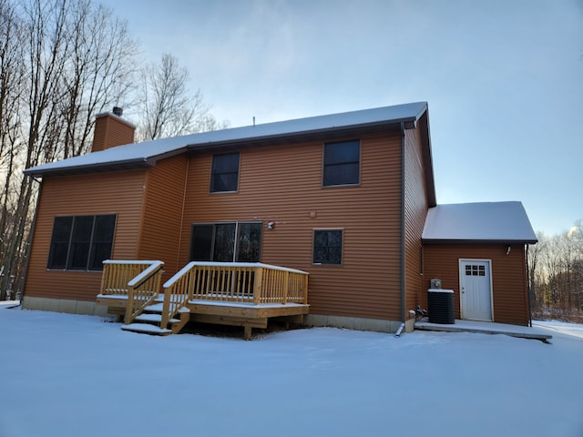 snow covered house featuring a wooden deck and central AC unit