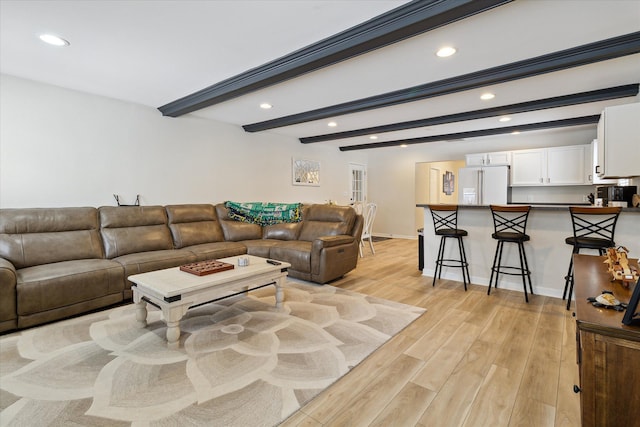 living room featuring beam ceiling and light wood-type flooring