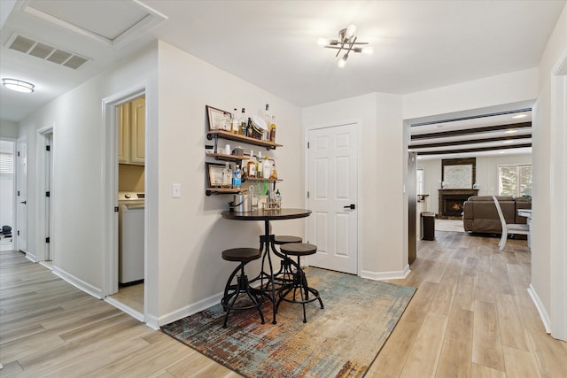 hallway with washer / dryer and light hardwood / wood-style flooring