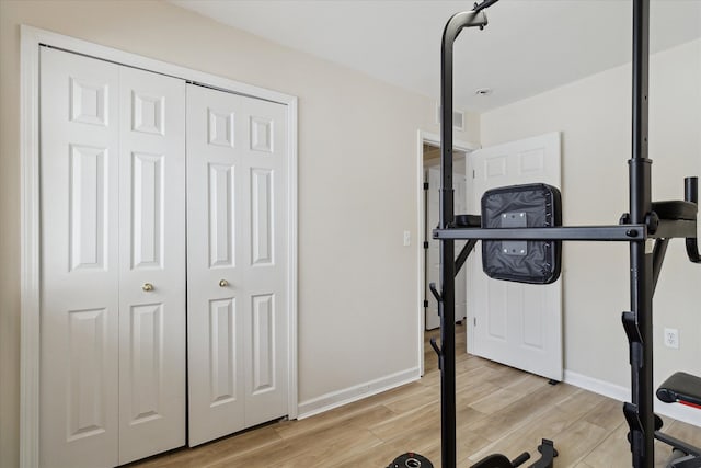 workout area with light hardwood / wood-style floors