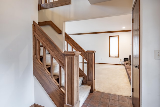 stairway featuring carpet and baseboards