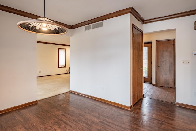 unfurnished room featuring visible vents, crown molding, baseboards, and wood finished floors