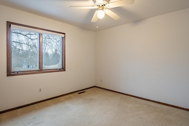 unfurnished room featuring baseboards, visible vents, a ceiling fan, and light colored carpet