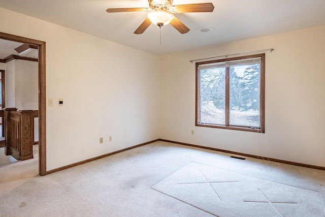 unfurnished room featuring a ceiling fan, visible vents, light carpet, and baseboards