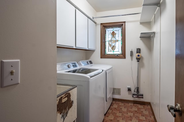 washroom featuring washing machine and dryer, cabinet space, visible vents, and baseboards