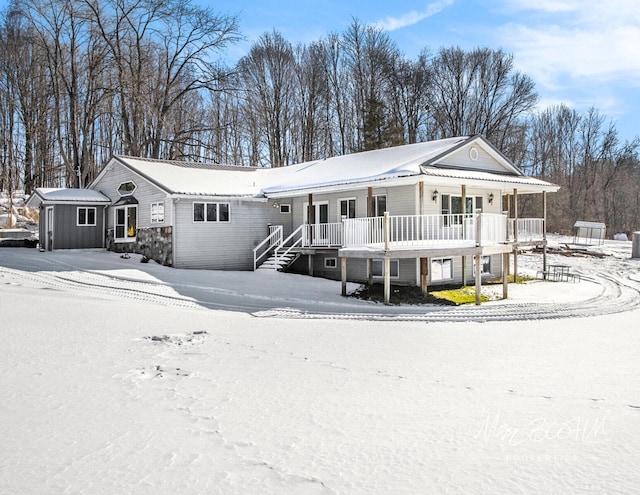 view of front of home with covered porch and a storage shed