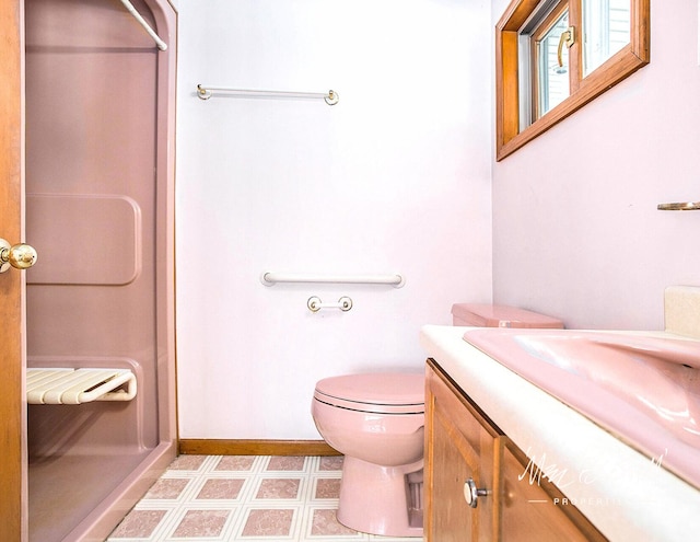 bathroom featuring vanity, toilet, and walk in shower