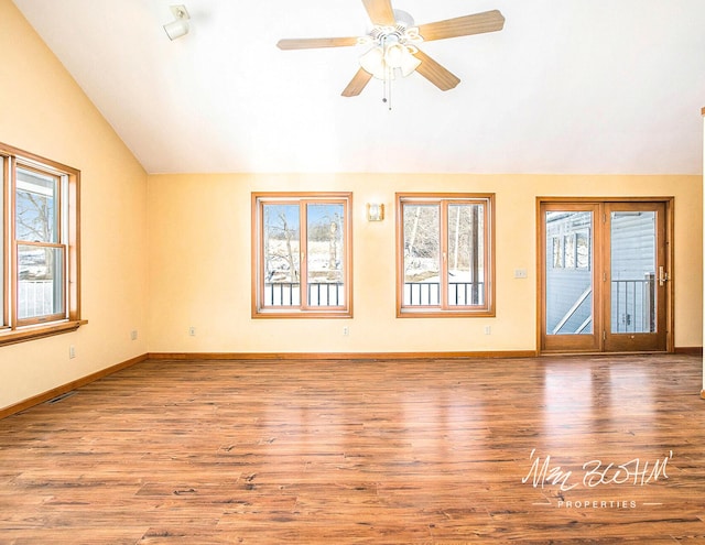 unfurnished living room featuring lofted ceiling, a healthy amount of sunlight, and light hardwood / wood-style floors