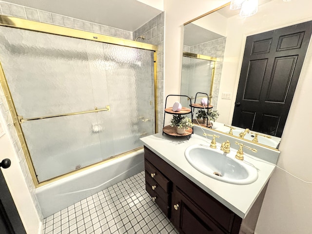 bathroom featuring vanity, tile patterned flooring, and combined bath / shower with glass door