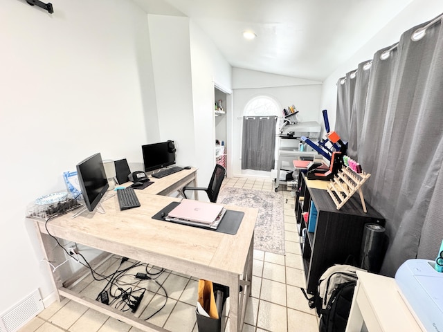 home office featuring lofted ceiling and light tile patterned floors