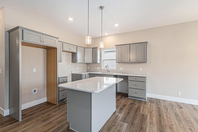 kitchen with pendant lighting, sink, gray cabinets, and a kitchen island