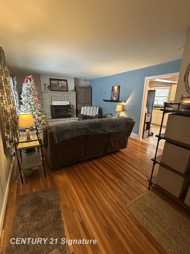 bedroom with hardwood / wood-style flooring, sink, and a fireplace