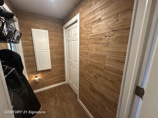 interior space with wooden walls and dark hardwood / wood-style flooring