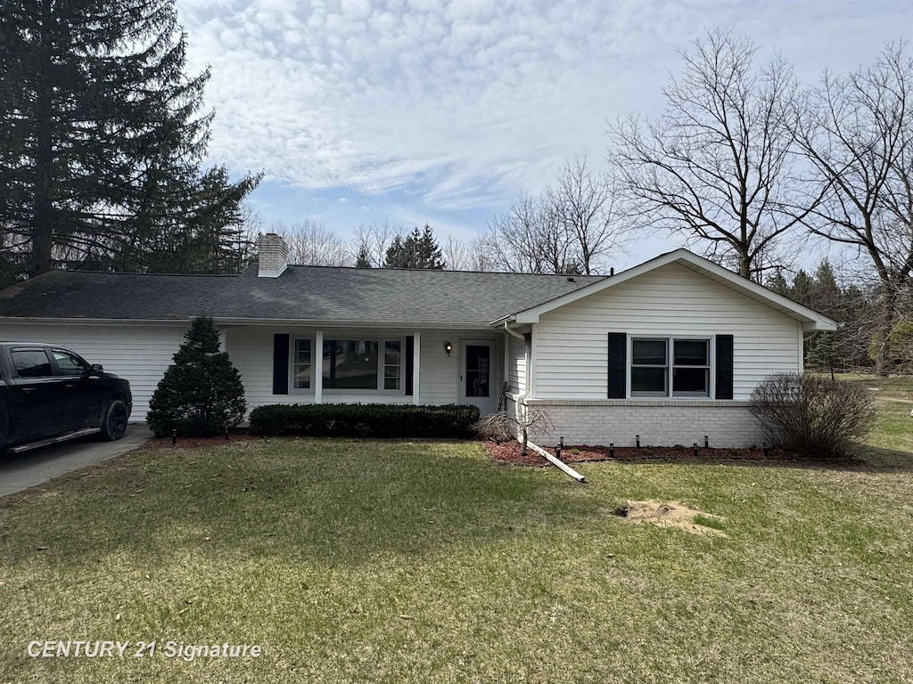 ranch-style home with brick siding, a front yard, a shingled roof, and a chimney