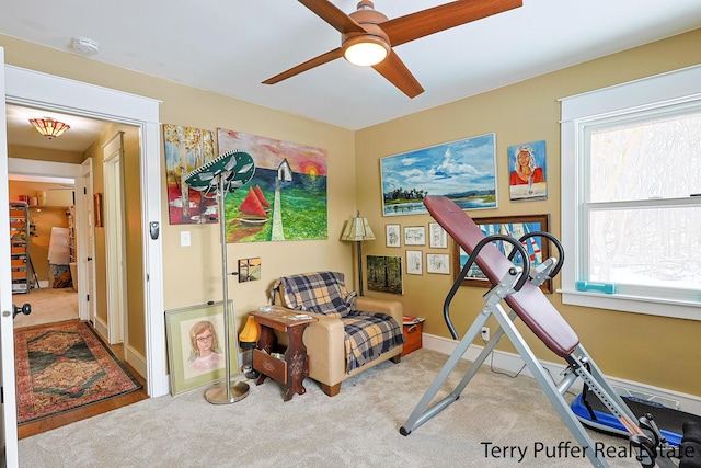 exercise room with ceiling fan and light carpet