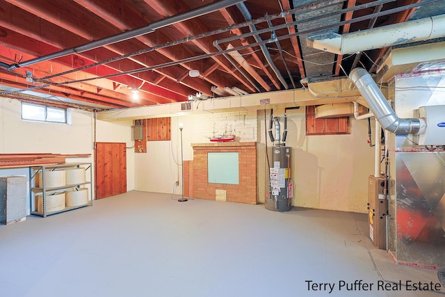 basement with gas water heater, heating unit, and electric panel