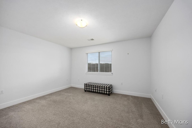 empty room featuring baseboards, carpet flooring, and visible vents