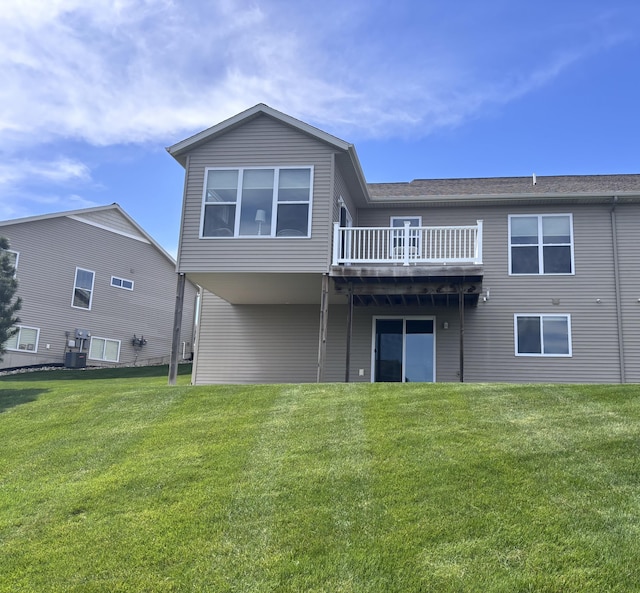 rear view of property featuring a lawn and a wooden deck
