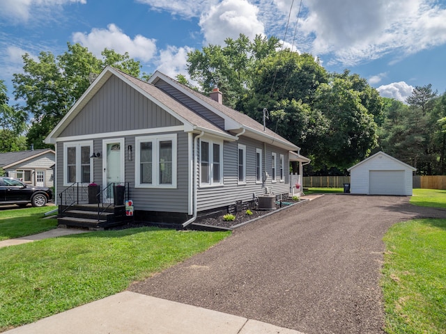 view of front of house featuring cooling unit, a garage, an outdoor structure, and a front yard