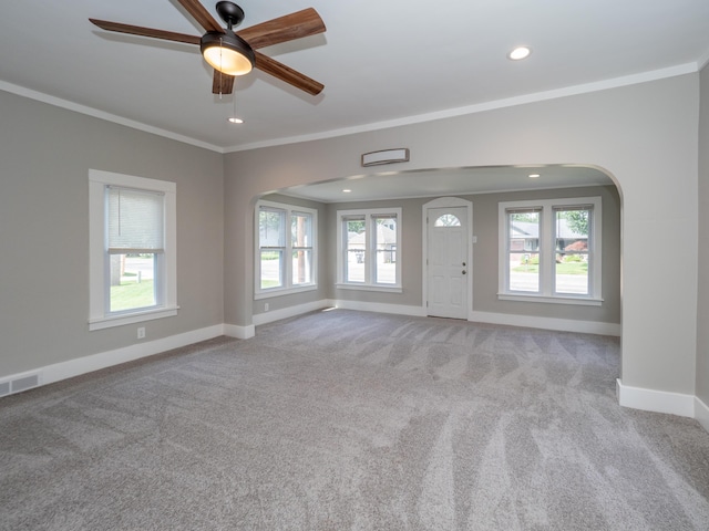 interior space featuring light carpet, ornamental molding, and ceiling fan