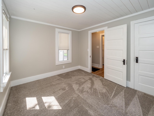 unfurnished bedroom featuring crown molding, wooden ceiling, and carpet flooring