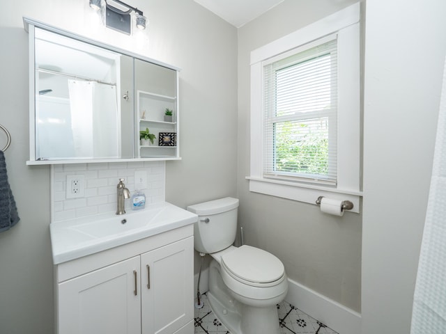 bathroom featuring tasteful backsplash, vanity, and toilet