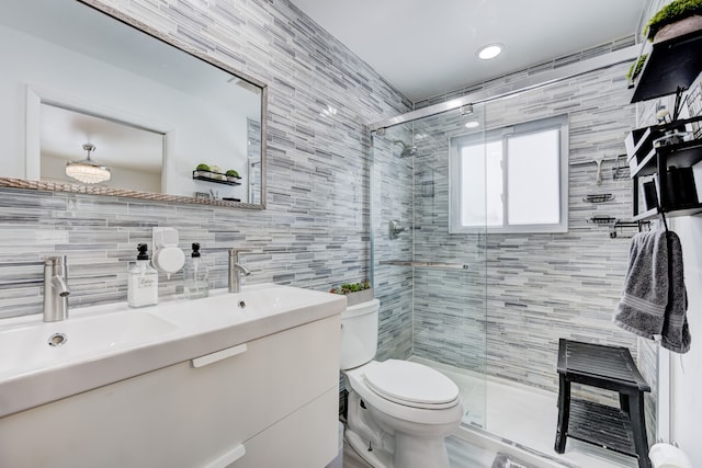 bathroom featuring vanity, tile walls, walk in shower, and toilet