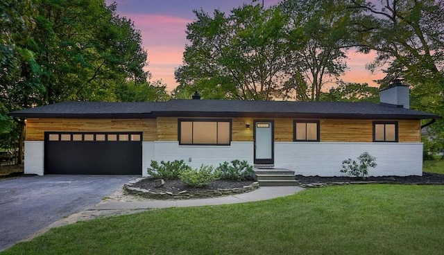 view of front facade with a garage and a lawn