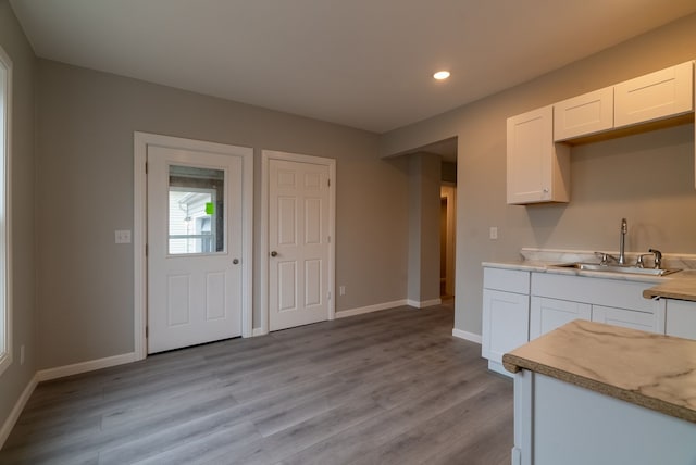 kitchen featuring sink, light hardwood / wood-style floors, and white cabinets