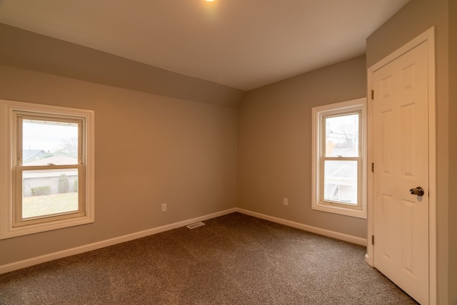 carpeted spare room with lofted ceiling and a healthy amount of sunlight