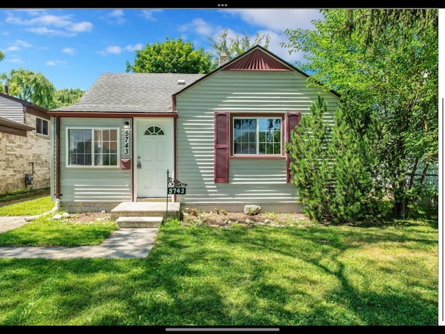 bungalow-style home with a front lawn