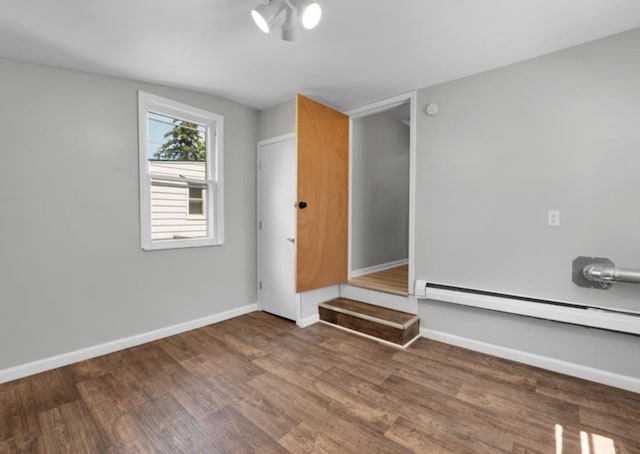 unfurnished room featuring dark hardwood / wood-style floors and baseboard heating