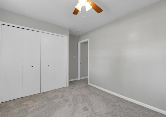 unfurnished bedroom featuring light colored carpet, a closet, and ceiling fan