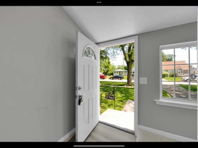 carpeted foyer entrance with lofted ceiling