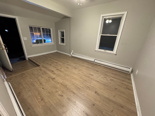 unfurnished room with a baseboard heating unit, light hardwood / wood-style floors, and ceiling fan