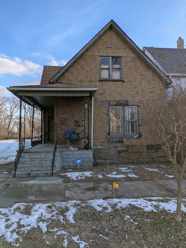 snow covered property with a porch