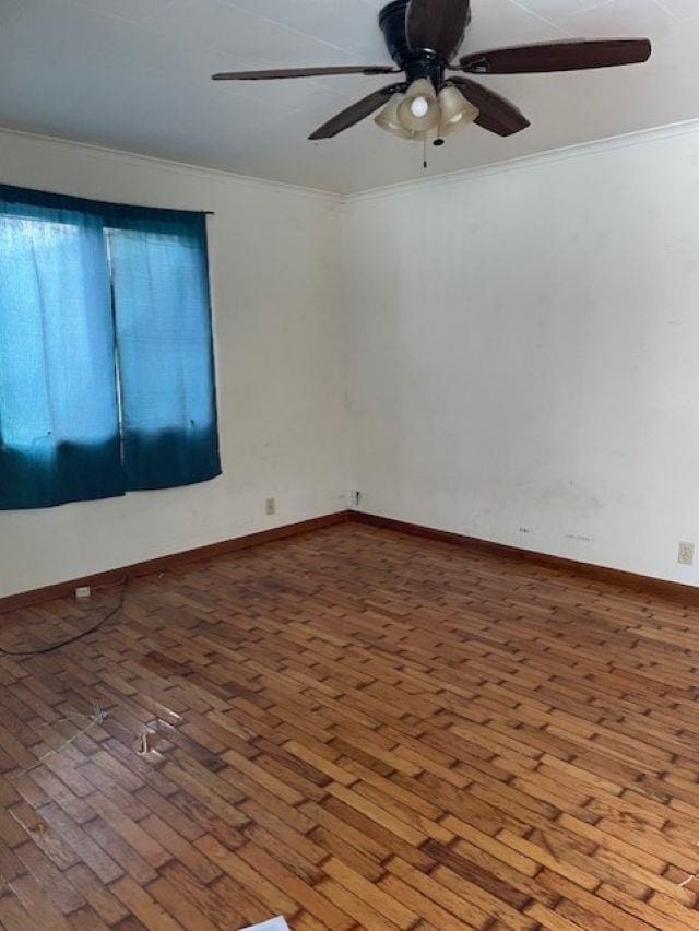 spare room featuring wood-type flooring, ornamental molding, and ceiling fan