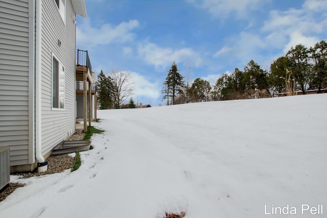 yard covered in snow featuring a balcony