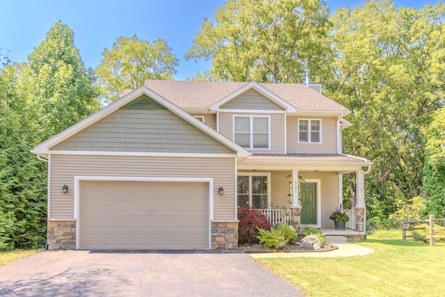 craftsman inspired home featuring a porch, a garage, and a front yard